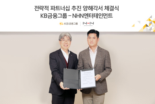 한동환 KB금융지주 상무(왼쪽)와 정우진 NHN엔터테인먼트 대표가 19일 판교 플레이뮤지엄에서 업무협약을 맺고 기념촬영을 위해 포즈를 취하고 있다. NHN엔터테인먼트 제공